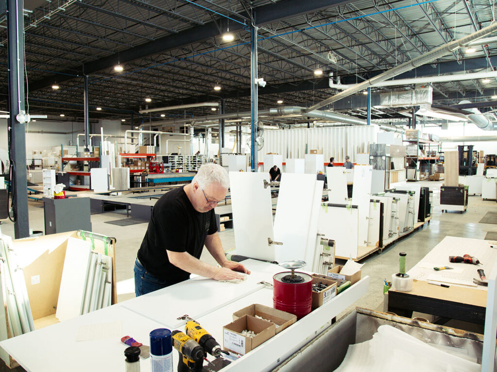 A Cuisi-n-art employee assembling a part on a workbench in the plant