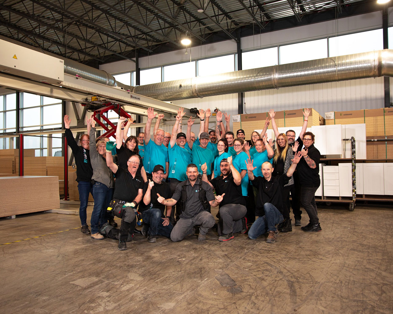 The Cuisi-n-art team celebrating with raised arms in the plant