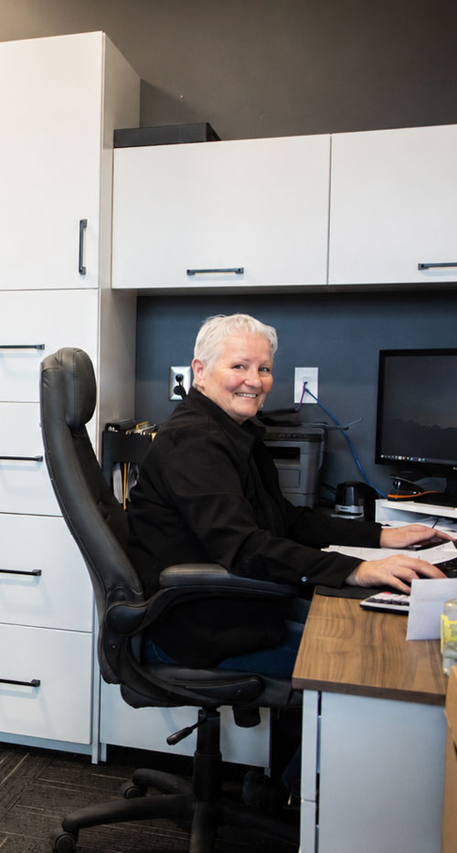 A smiling Cuisi-n-art employee at her desk