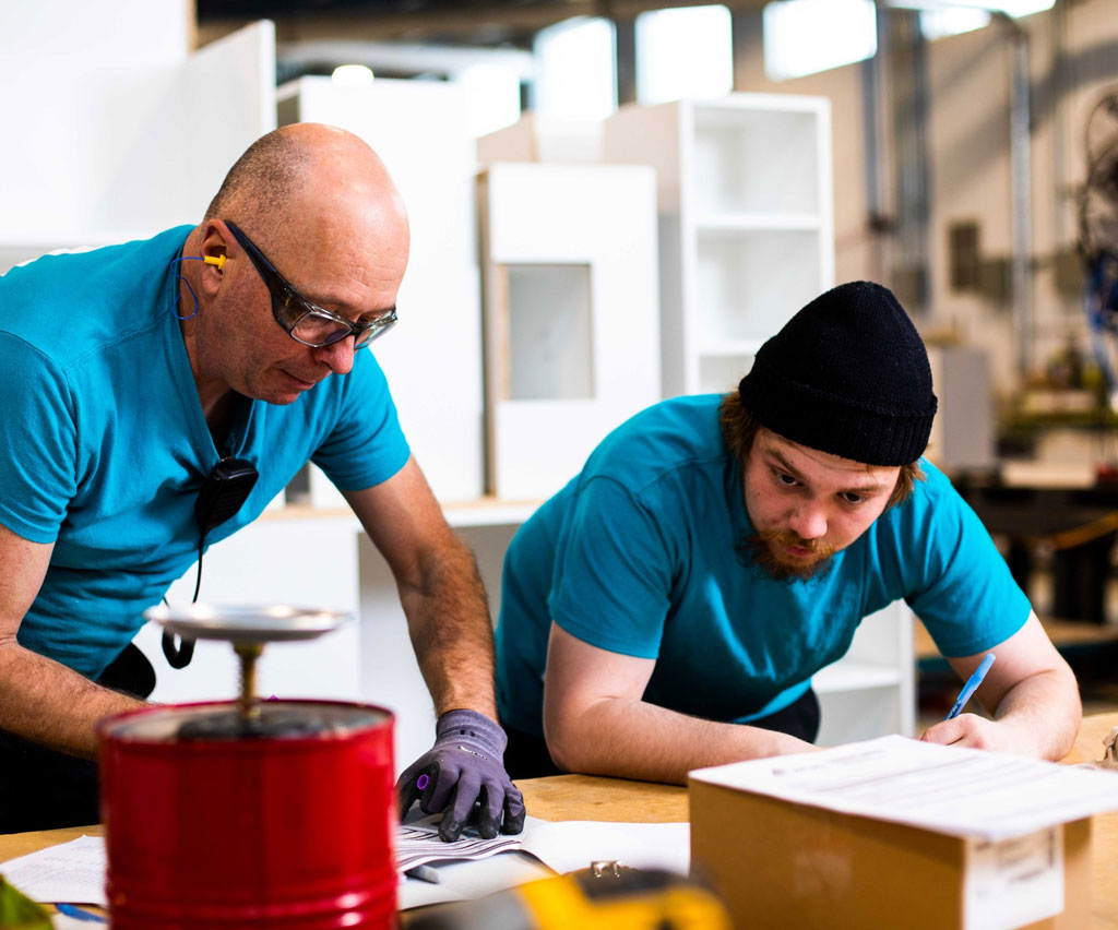 Two Cuisi-n-art employees checking a part in the workshop