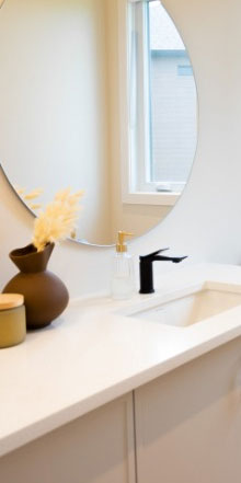 Vanité de salle de bain blanche avec un miroir rond